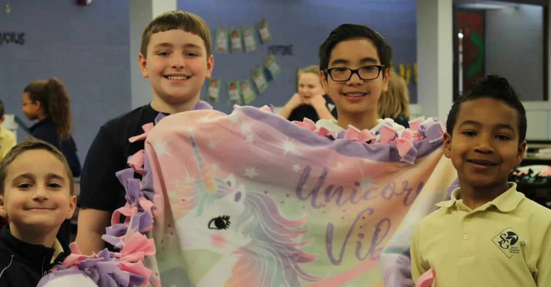 group of 4 students with a blanket